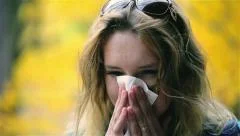 Girl blowing nose to hanky and feeling ill