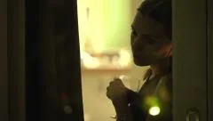 Young, sad, unhappy woman drinking wine and looking through the window  HD