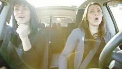 Women driving car singing and talking happy