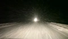 Night road with strong blizzard in moving car headlight, winter, pov