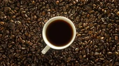 Cup of coffee rotation on the background of roasted coffee beans 4K