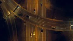 Aerial - Top down view of traffic crossing the bridge over highway at night