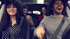 Four happy cool people having fun in car