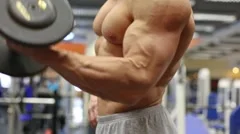 Muscular torso and hands with dumbbells of man standing