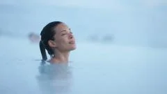 Geothermal spa - woman relaxing in hot spring pool  on Iceland