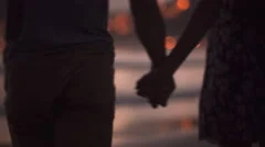 Young couple walking and holding hands at the beach