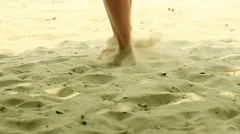 Women's feet are in the sand