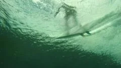 Underwater view of surfer riding wave and jumping off