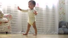 one year a small asian baby taking its first steps,dolly shot