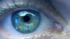 Reflection in the eye of the monitor while watching commercials. Extreme closeup