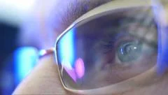 Reflection in the eye and glasses of the monitor when watching an action movie