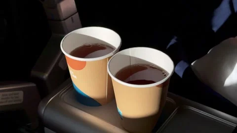 05 October 2024, KLM - two paper cups of black tea in sunlight on flight Stock Footage 308018150