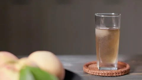 05 Peach Tea With Fresh Peach in Foreground Slow Slider Shot Vídeos de archivo 344246444