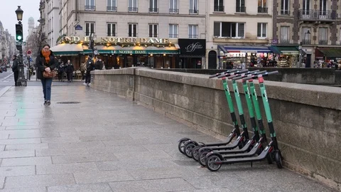 05 Rainy gray winter day Paris hire electro scooters for rent standing on str Stock Footage 100814766