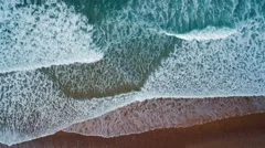 Overhead Aerial drone footage of sea waves reaching shore
