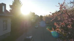 AERIAL: Sunrise sun shining over the roofs in blooming suburbia