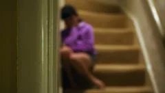 Upset little girl on stairs, out of focus tracking reveal