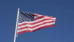 United States of America flag in front of blue sky slow waving on wind slow