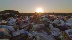 Sun setting over landfill site of domestic waste jib shot