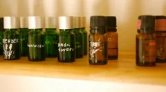 Signed glass bottles of essential oil for aromatherapy on spa salon wooden shelf