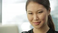 Young asian business woman working with her laptop in office. Close up.