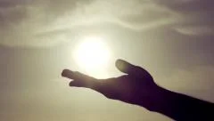 Grasping the sun with palm/fingers slow motion