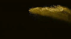 Powder flying in midair against black background. Slow Motion.