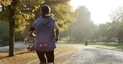 Runner woman running in park exercising outdoors fitness tracker wearable