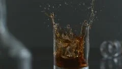 Ice is dropped into glass of whisky in slow motion; shot on Phantom Flex 4K 