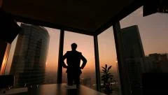 businessman looking out the window in a contemplative way, Dolly shot, sunset