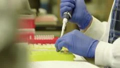 Scientist in lab injects liquid into tubes - 4K UHD