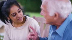 4K Caring home support worker with elderly man in the garden