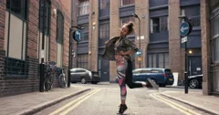 Contemporary funky mixed race woman street dancer dancing freestyle in the city