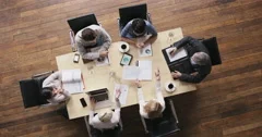 Top view diverse business people meeting at boardroom table discussing financial