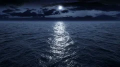 Flying over the ocean at night. Facing the moon. Full HD