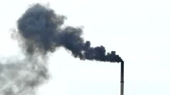 Air pollution from dark smoke factory smokestack