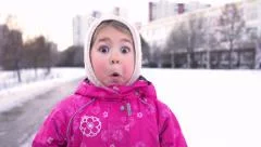 Close-up of 4 Year Old Little Funny Girl Acts Very Surprised on winter street.