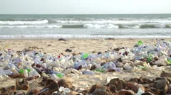 pan across polluted beach  with plastic bottles