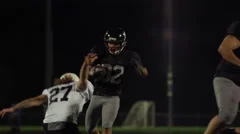 A running back football player jumps over his opponents to score a touchdown.