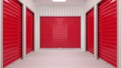 Corridor full of storage units with red door and siding panels on walls.