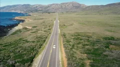 Aerial drone view of car driving down coast country road in Big Sur, California