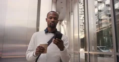 African American businessman walking through city using smart phone