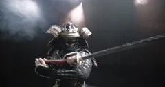 Japanese samurai in the historical suit threatens with a sword , posing for the