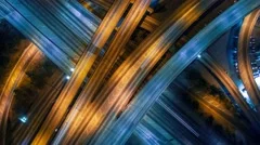 Vertical aerial view panning up over traffic on freeway interchange at night 4K