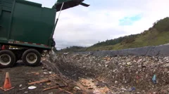 Trash spills from garbage truck in to trench at landfill