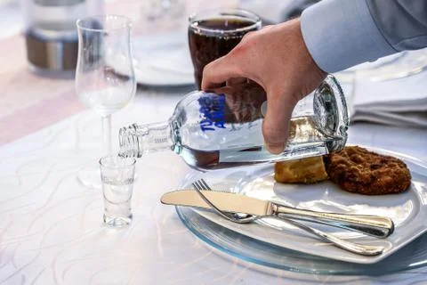 06.07.2019 Kobenz Germany hand with a bottle of Absolut Vodka poured into a s Stock Photos