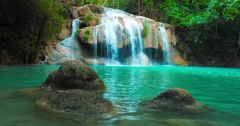 Beautiful waterfall cascade and natural pond with blue water in jungle forest