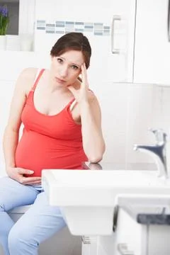 Pregnant Woman Suffering With Morning Sickness In Bathroom xkwx 30, at home, bathroom, belly, bump, caucasian, holding, ill, illness, indoors, looking at camera, maternity, morning sickness, nausea, one person, people, person, portrait, pregnancy, pregnant, sad, sitting, stomach, thirties, touching, toxicosis, unhappy, unwell, vertical, woman, women