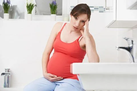 Pregnant Woman Suffering With Morning Sickness In Bathroom xkwx 30, at home, bathroom, belly, bump, caucasian, holding, horizontal, ill, illness, indoors, looking at camera, maternity, morning sickness, nausea, one person, people, person, portrait, pregnancy, pregnant, sad, sitting, stomach, thirties, touching, toxicosis, unhappy, unwell, woman, women