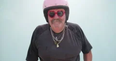 Senior adult man wearing pink helmet and dancing